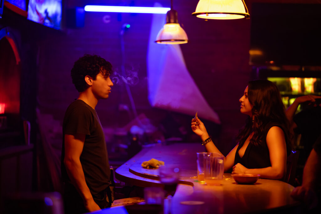 A man and a woman speak in a bar in the film a hundred lies