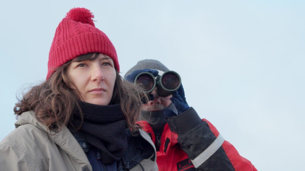 Two researchers look at something in the documentary Antarctic Voyage